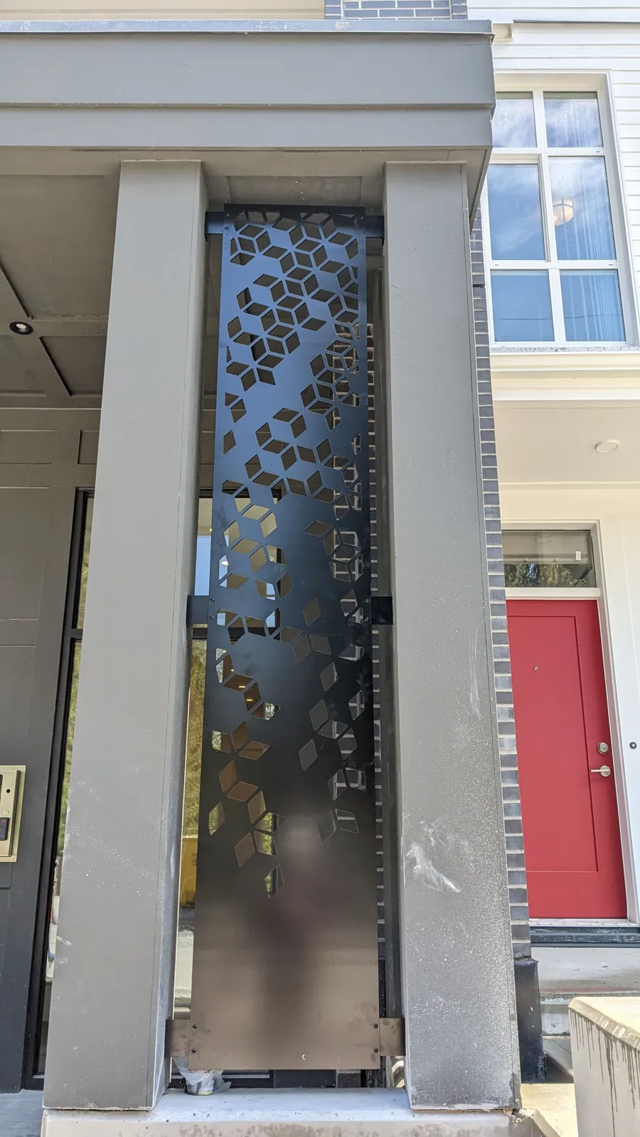 Decorative laser-cut metal screen panel at a building entrance