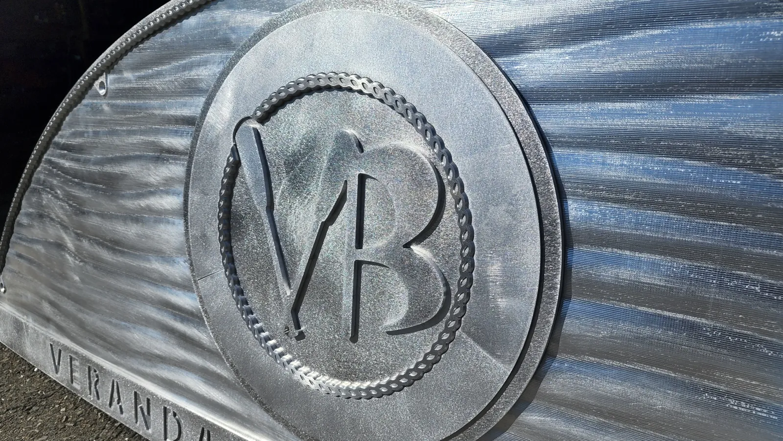 Brushed metal emblem with a machined monogram