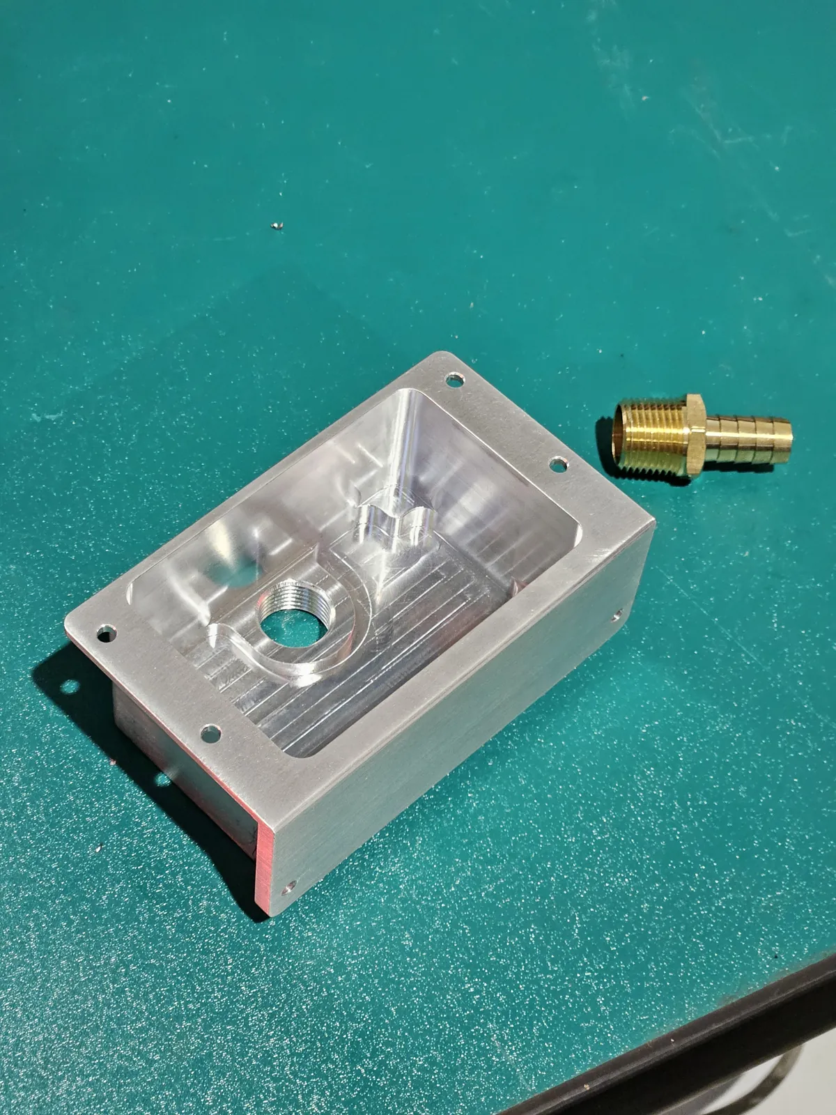 Small CNC machined aluminum block with a brass fitting