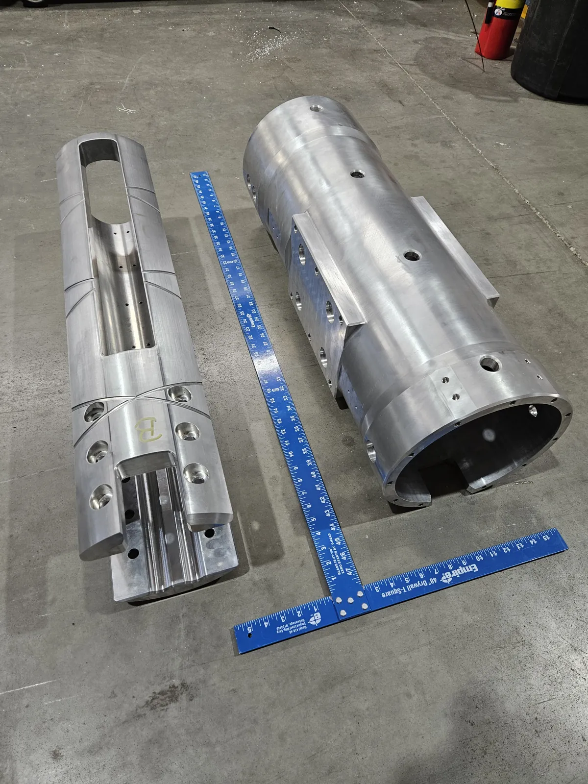 Turned and milled aluminum cylinders next to a square