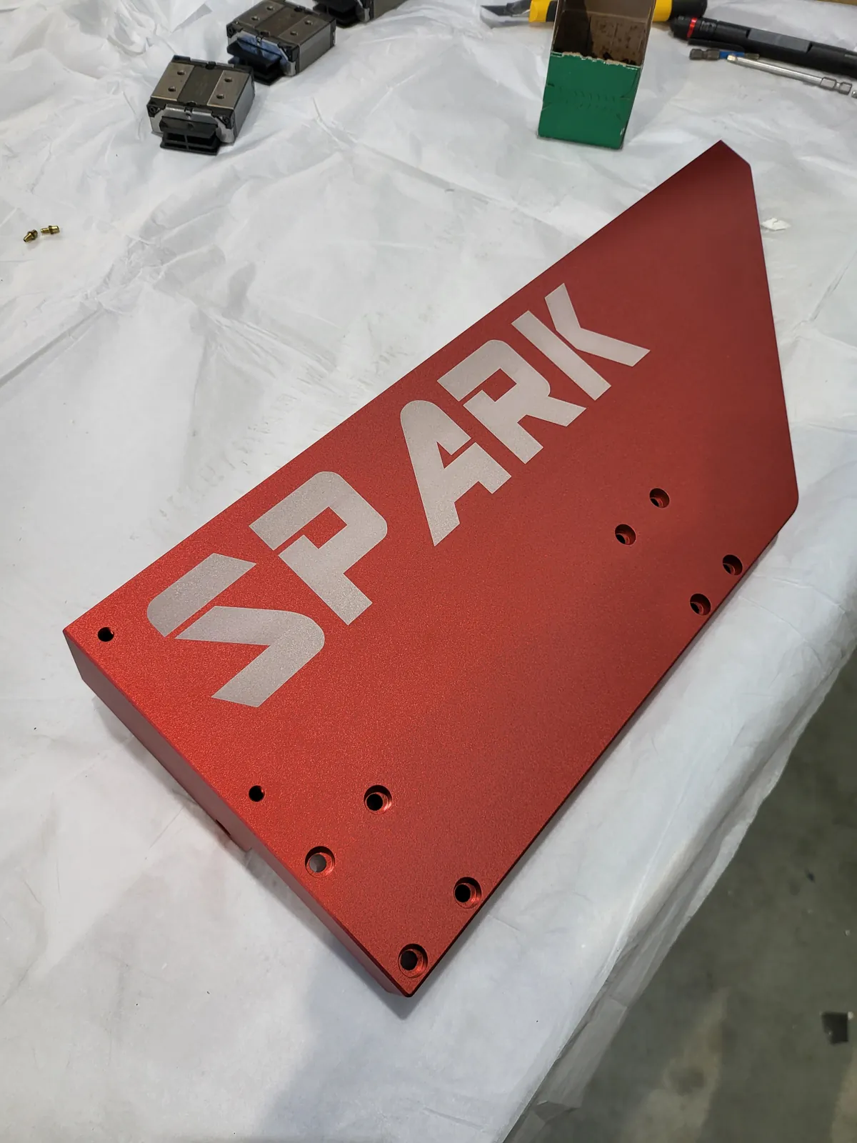 Red powder-coated plate with laser-cut SPARK lettering
