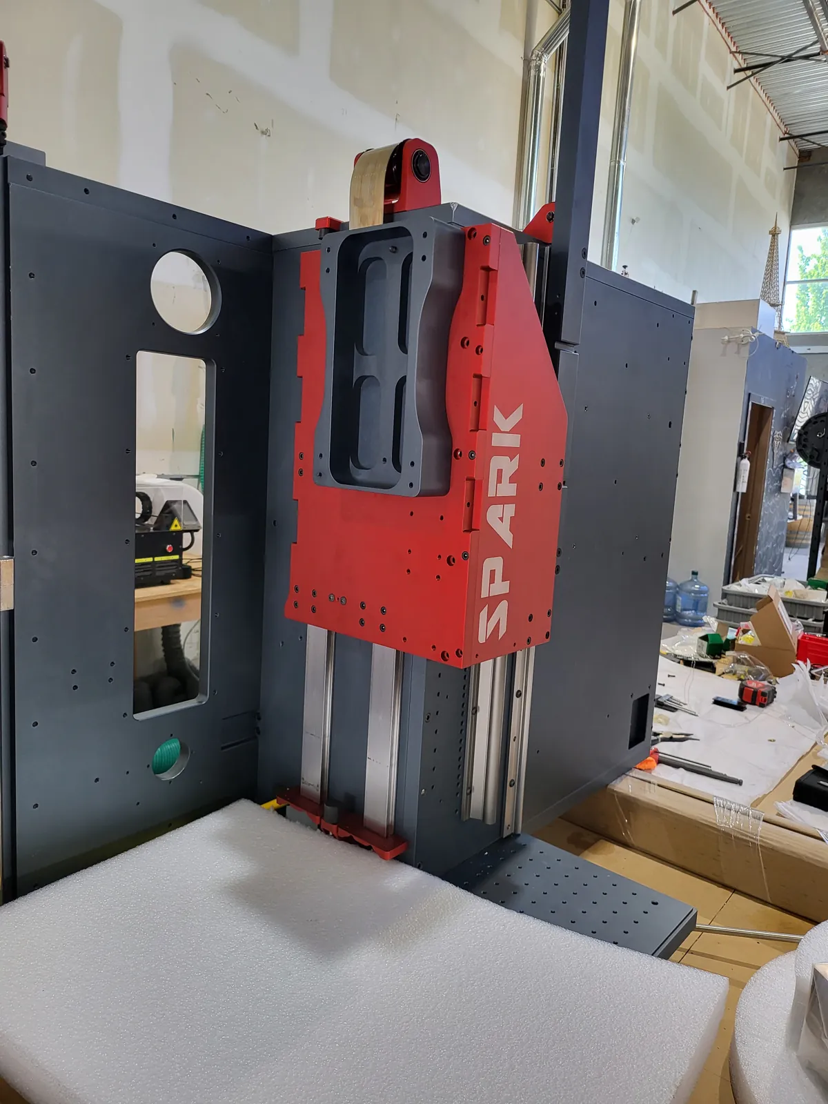 Spark-branded red fabricated fixture plate on a machine frame