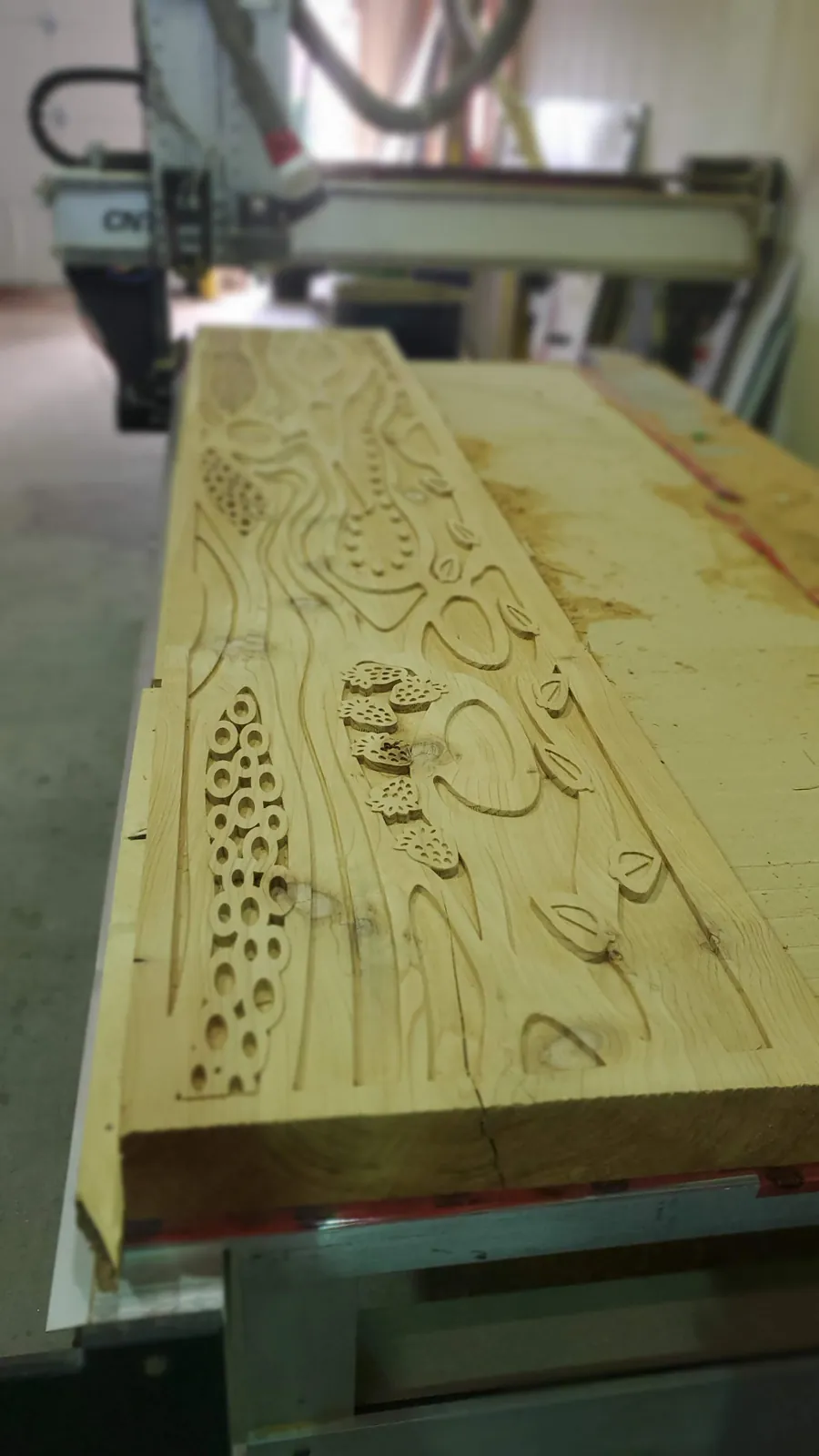 Router-carved wood panel with a floral pattern